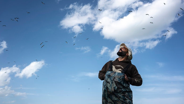 Nika Paposhvili, a conservation biologist, counting birds flowing above Lake Tabatskuri