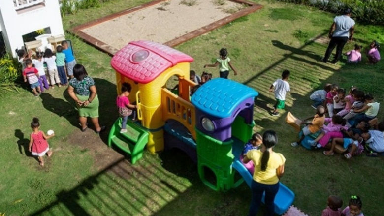 Children playing in playground supervised by adults