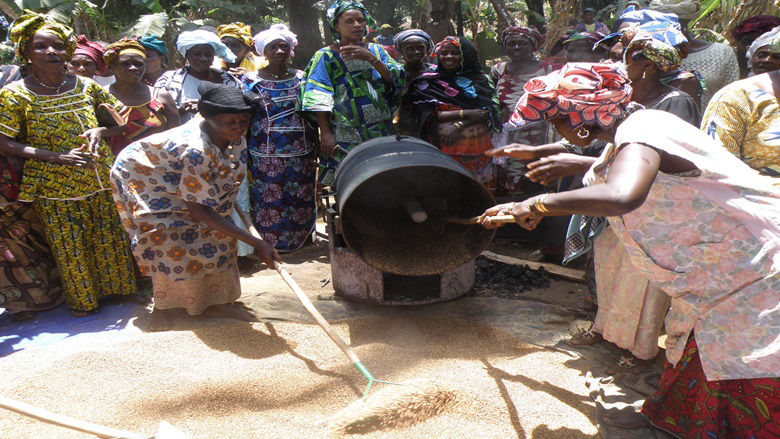 women raking wheat grains