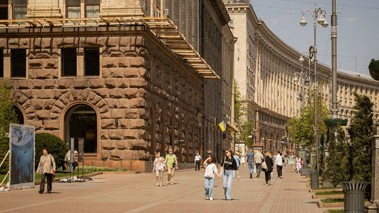 People strolling along a sidewalk in Kyiv, Ukraine on a warm April day