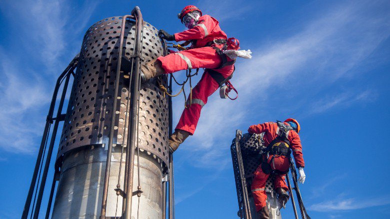 Oil and gas workers inspecting a flare