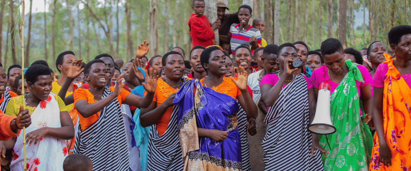 African community in colorful clothes stand together outdoors.