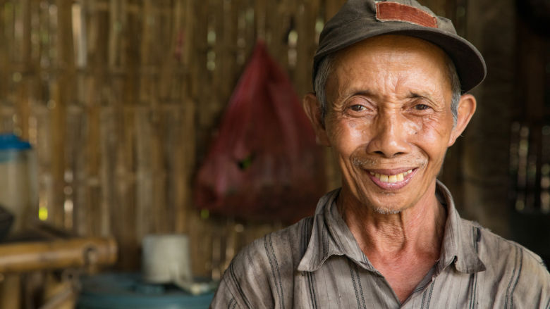 Senior Indonesian farmer smiling portrait in hut 