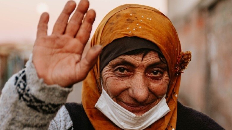 A Turkish woman who received a digital government payment for social assistance waives at the camera