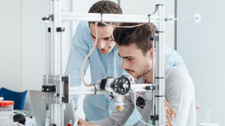 University student researchers use a 3D printer in a laboratory