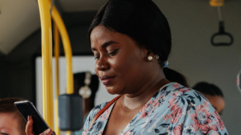 A woman in a bus working on her phone