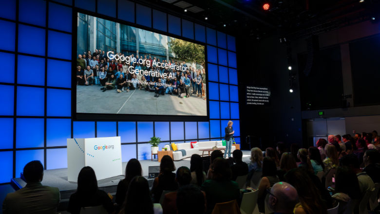 Woman on stage at Google.org Impact Summit speaking to an audience