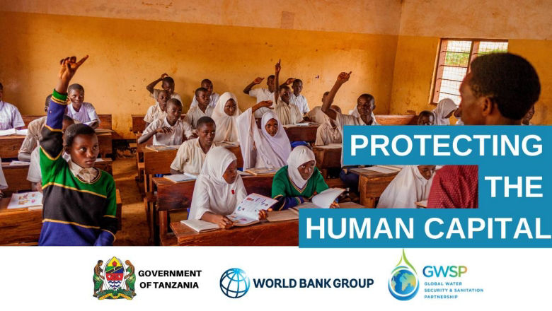 Students raise their hands in a classroom in rural Tanzania.