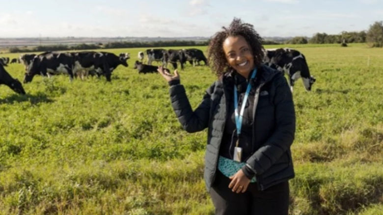 Ethiopian woman pointing to cows in the background