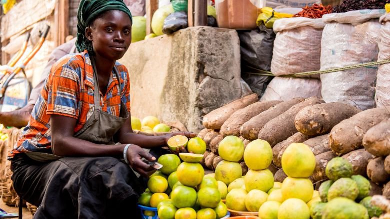 A person selling oranges and fruit in a Nigerian market