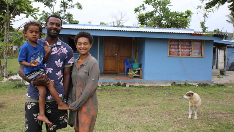 Family standing in front of their house in Vanuatu