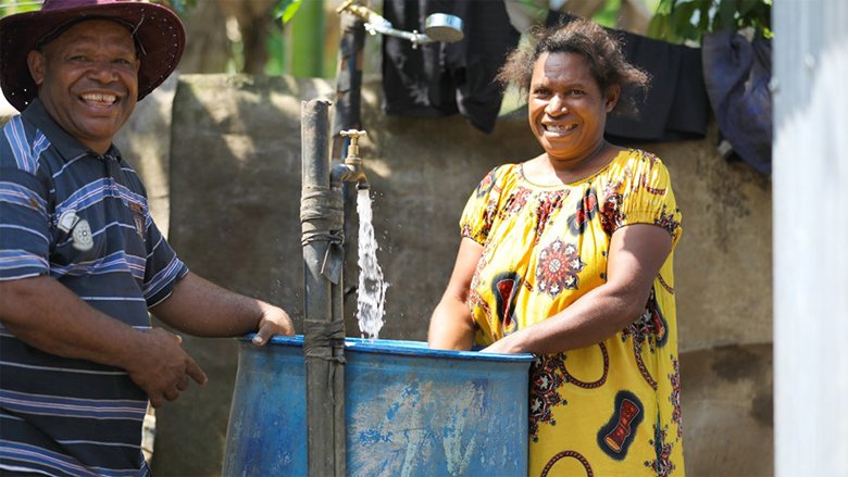 A photo of a man and woman standing by a water tap