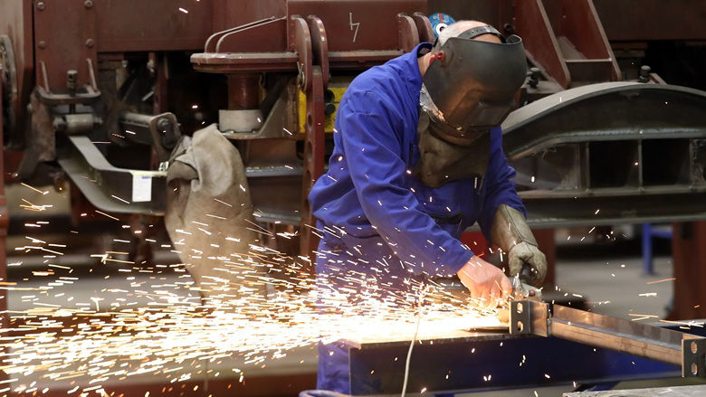 A worker cutting a piece of metal on a workshop floor in Croatia