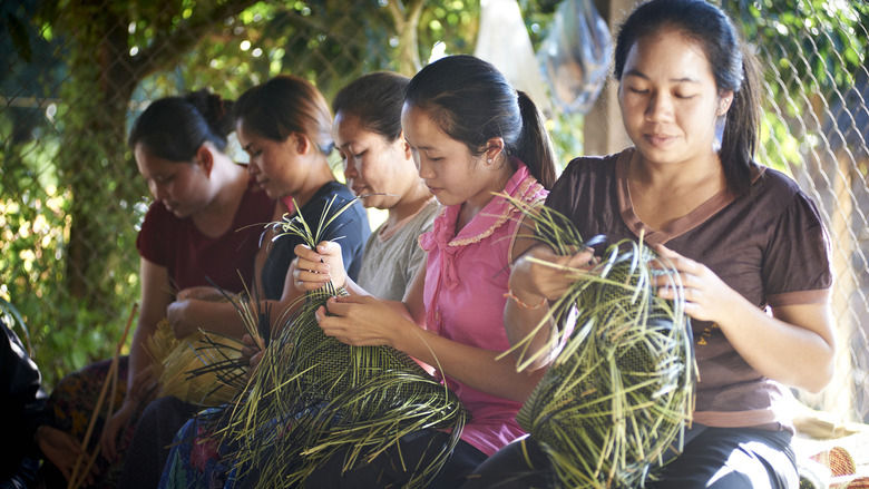 Lao women weave baskets by hand from wild grasses. 