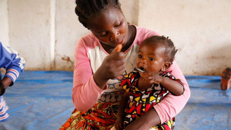Woman feeds her child in Angola