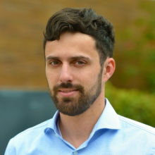 Male with brown hair and beard wearing powder blue blouse