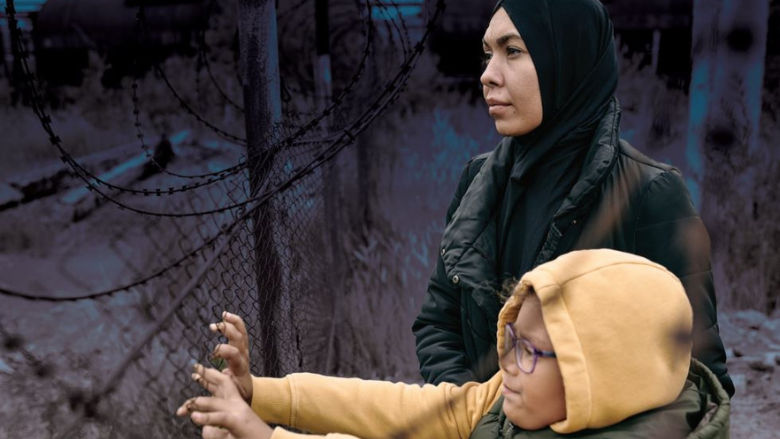 A woman and girl in front of a fence