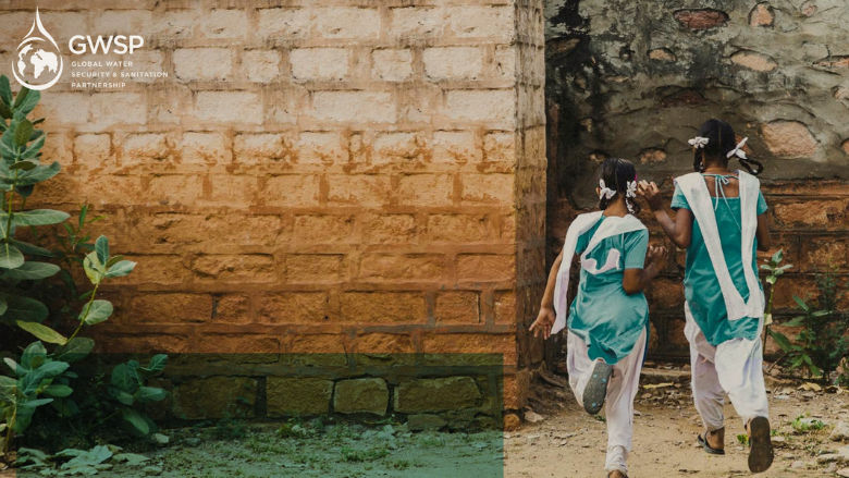 Two young girls from South Asia run towards their school