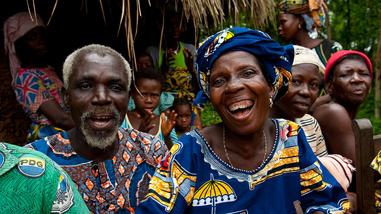 Older man and women in Benin laugh with their community