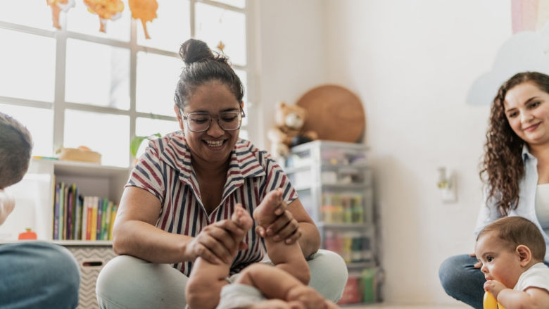 Madre jugando con un bebé en el piso. 