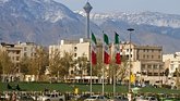 Alborz Mountains, in the city of Tehran, appear behind three Iranian flags.