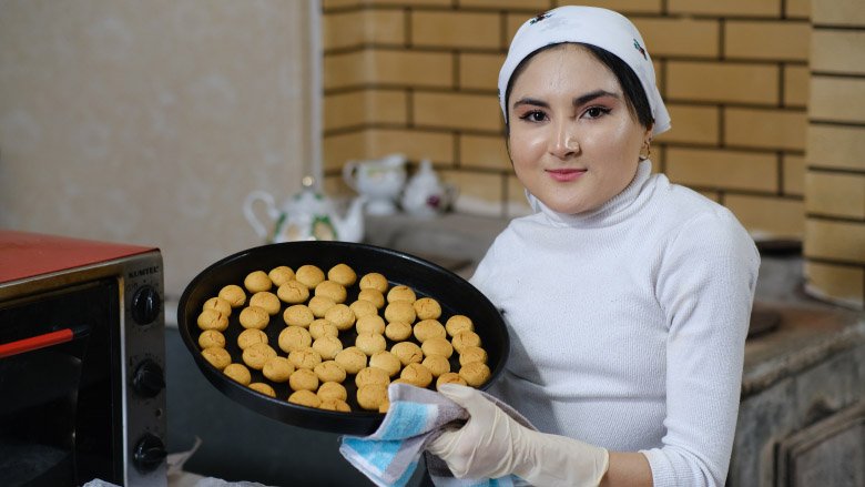 Young woman with a tray of cookies