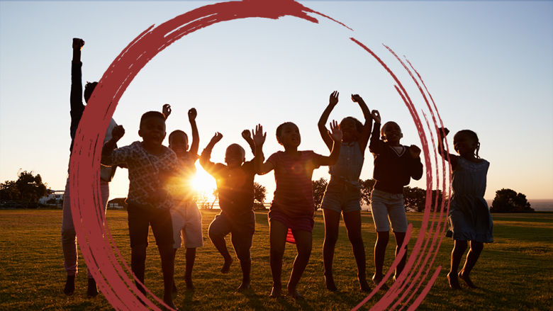 African school children jumping outdoors at sunset