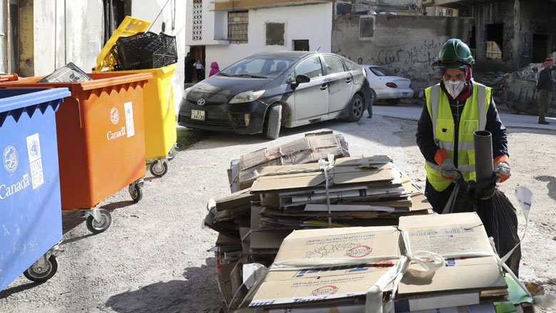 Jordanian woman collects the trash in dedicated containers before she transports it to the station.