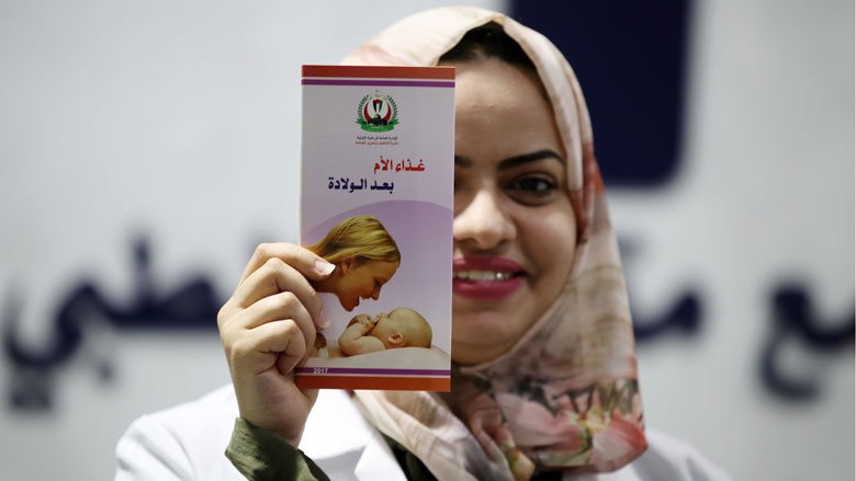 Dr. Haya Hijazi presents a brochure on women's health at the Maqat Medical Clinic in Gaza City