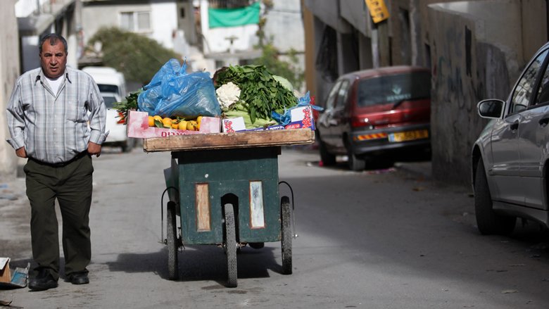 A vegetable trader having hard time selling the goods, West Bank. 