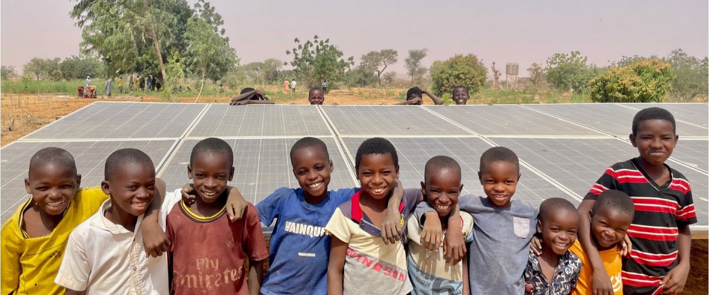 Des enfants devant un panneau solaire