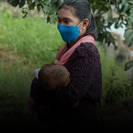 Girly, a woman from the BARMM, carries her baby at home. Just a few hours earlier, Girly received a dose of COVID-19 vaccine 