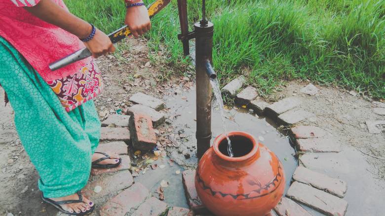 Woman pumping water from a well in India. Photo credit: Nishasharma/Shutterstock