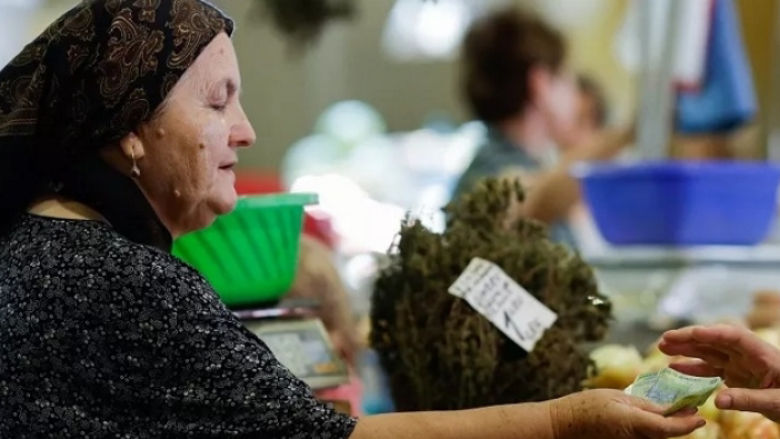 woman handling cash for vegetables at the market in Romania