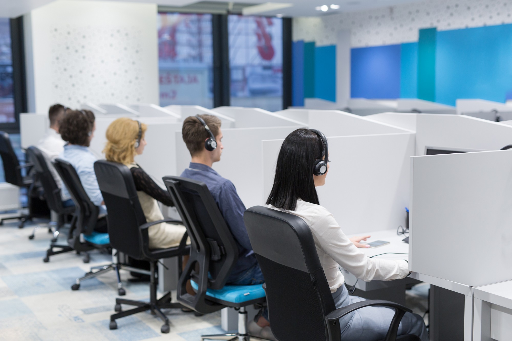 group of young business people with headset working and giving support to customers in a call center office