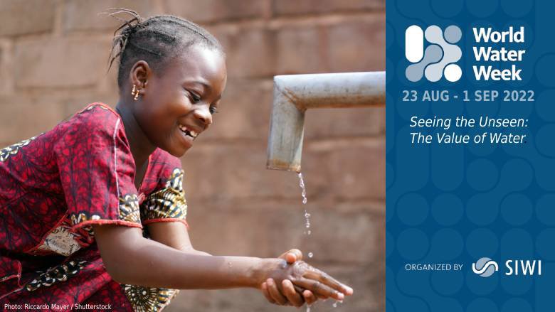 A young girl washes her hands using an outdoor tap.