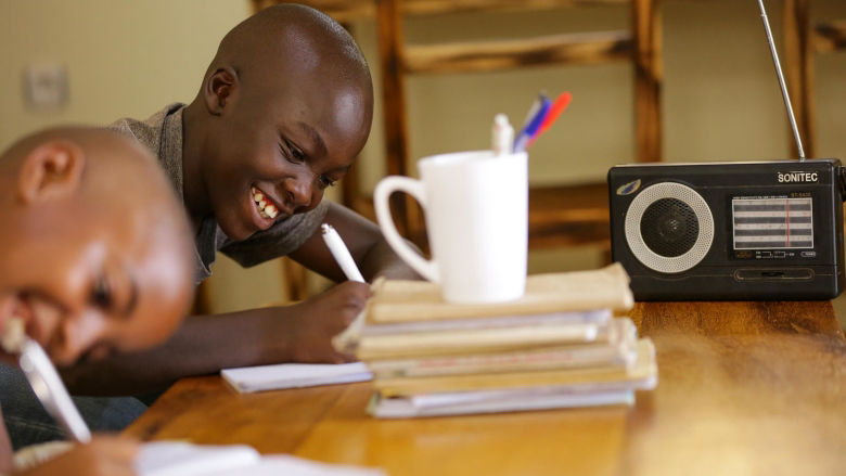 Kevin, 11, listens to radio lessons at home while his primary school is closed