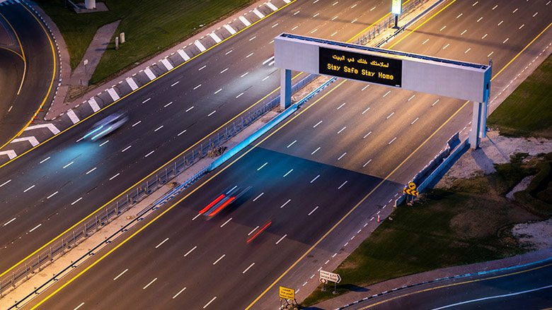 Empty highway in Dubai because on coronavirus. Sign advertising the Stay Home Stay Safe campaign.