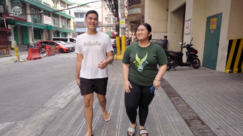 Two students walk down a street in Manila.