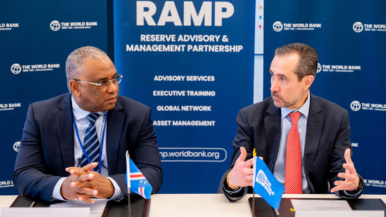 Jorge Familiar and Central Bank Cabo Verde Governor sitting at signing table talking