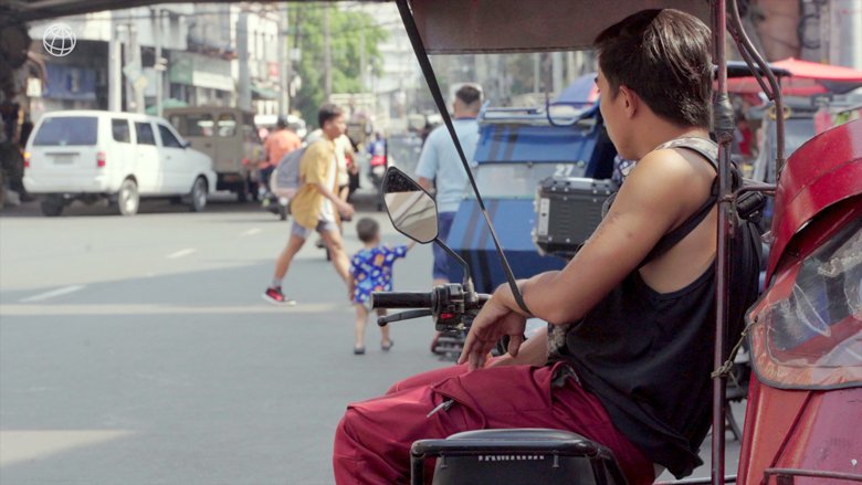 A man sits on a tricycle in Manila.