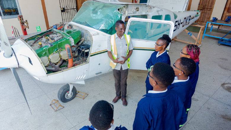 NIT students pursuing an Aircraft Maintenance Engineering degree listen to an instructor and check out a plane engine during 