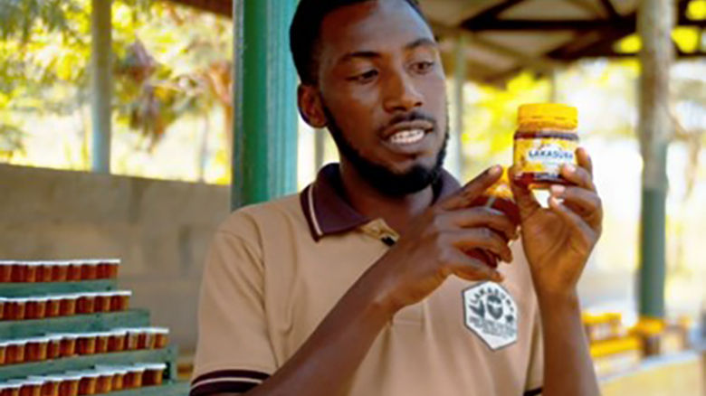 Bee keeper holding a jar of honey