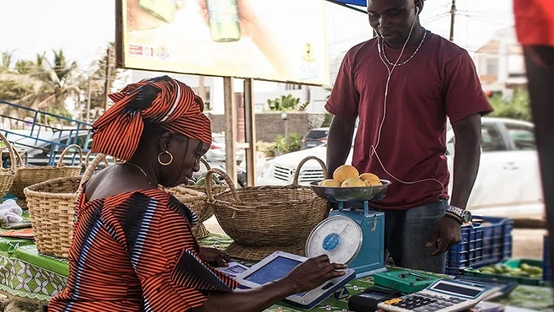 woman is entering the vegetables sale transaction on tablet