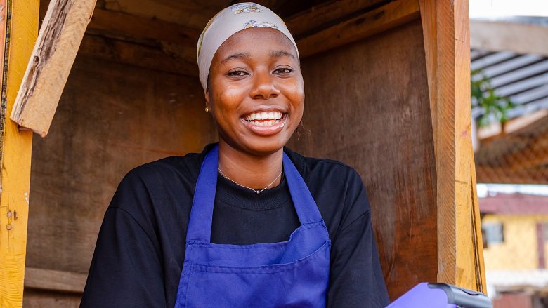 African lady working in a kiosk smiling